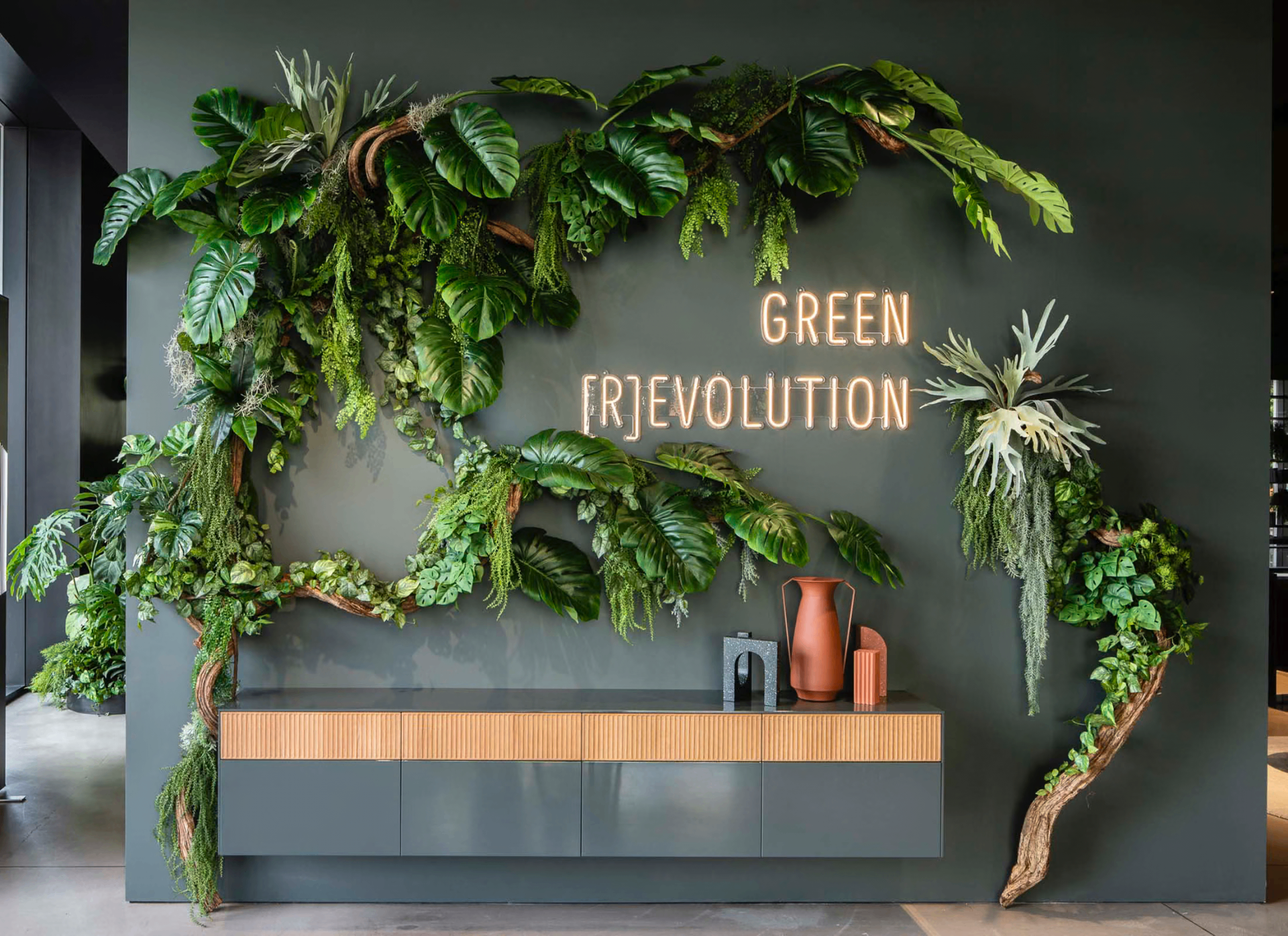 Green [R]evolution living wall at Evolution Sustainability Property — lush green foliage, natural wood and warm terracotta tones reflecting our sustainable brand ethos